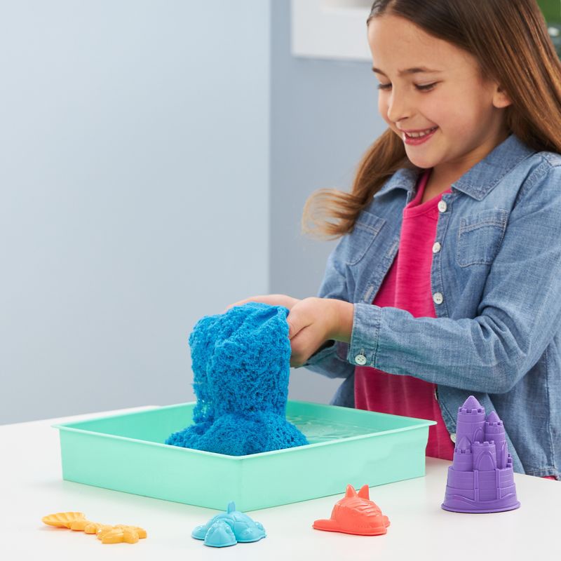 Kinetic Sand Box mit flüssigem Sand und blauer Unterlage